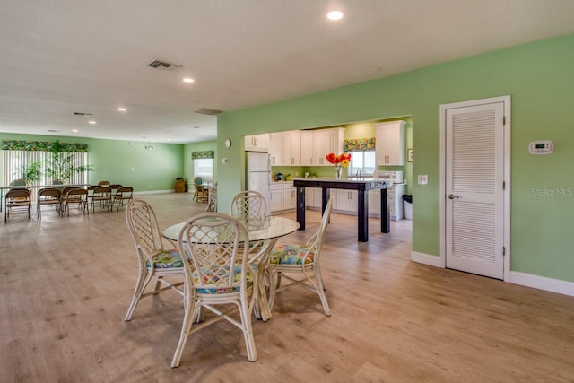 dining space featuring sink and light wood-type flooring