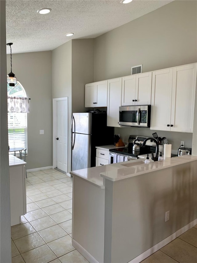 kitchen featuring stainless steel appliances, white cabinetry, light tile patterned floors, and kitchen peninsula