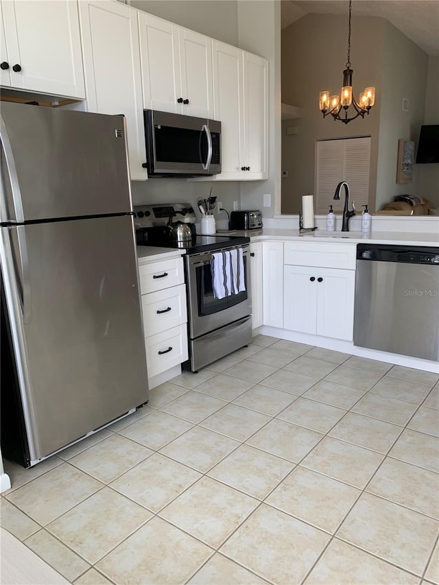 kitchen featuring sink, stainless steel appliances, vaulted ceiling, and light tile patterned flooring