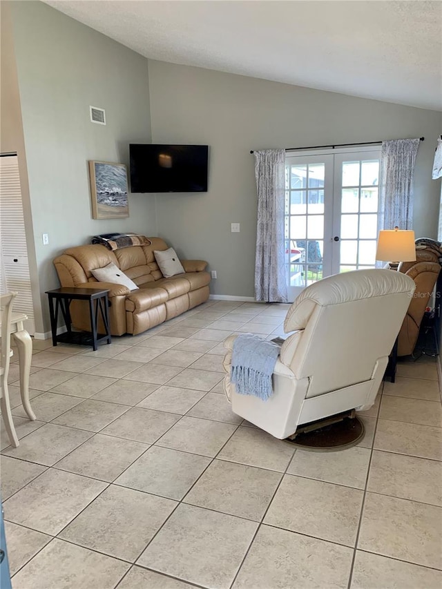 living room with lofted ceiling, french doors, and light tile patterned flooring