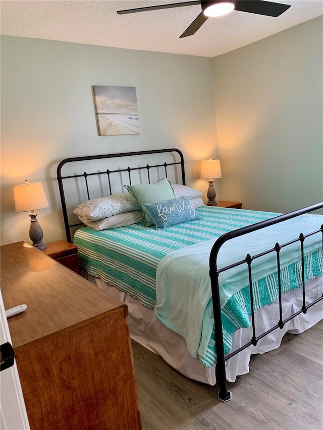 bedroom featuring ceiling fan, a textured ceiling, and hardwood / wood-style flooring