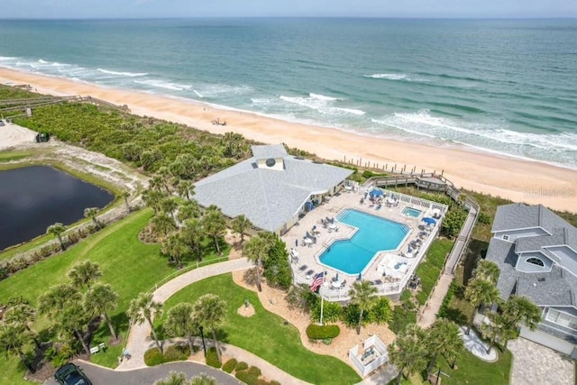 drone / aerial view featuring a beach view and a water view