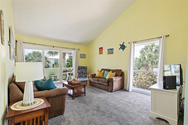 living room with light carpet, plenty of natural light, and high vaulted ceiling