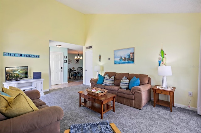 carpeted living room with high vaulted ceiling and a notable chandelier