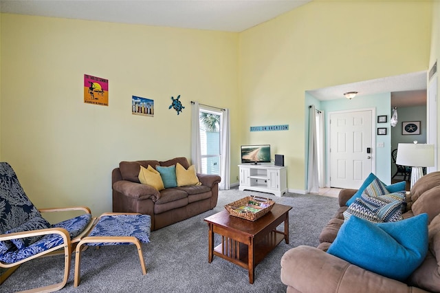 carpeted living room with a towering ceiling