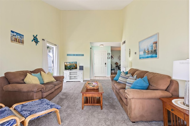 carpeted living room with a towering ceiling