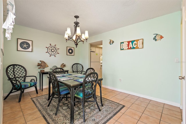 dining room with a textured ceiling, a notable chandelier, and light tile floors