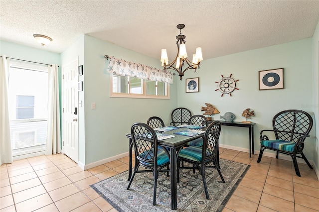 tiled dining room featuring a textured ceiling and a notable chandelier