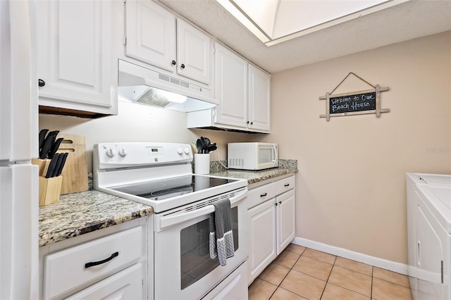 kitchen with light stone counters, white appliances, light tile flooring, and white cabinetry