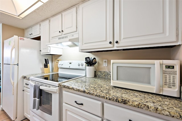 kitchen featuring white cabinets, a textured ceiling, white appliances, and light stone counters