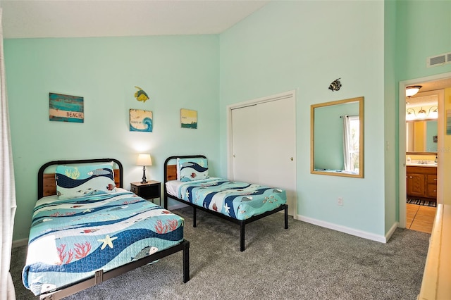 carpeted bedroom with high vaulted ceiling, sink, and ensuite bathroom