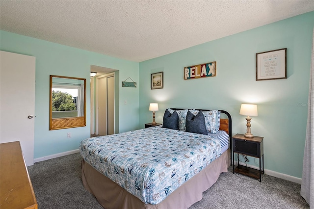 bedroom featuring dark colored carpet and a textured ceiling