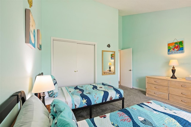 bedroom with a closet, light carpet, and a high ceiling