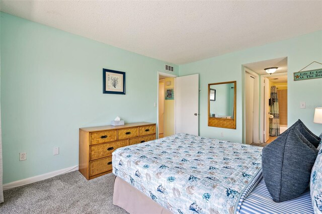 bedroom featuring light carpet and a textured ceiling