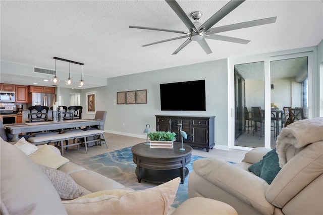 living room with a textured ceiling and ceiling fan