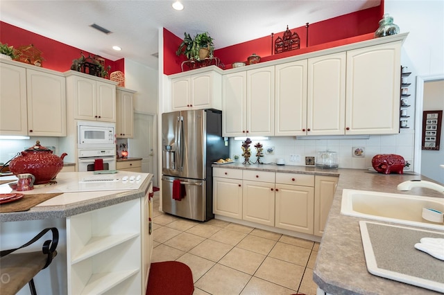 kitchen featuring sink, white appliances, backsplash, and light tile floors