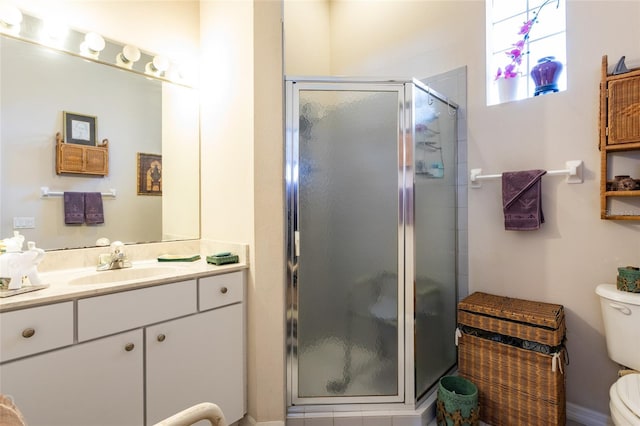 bathroom with a shower with door, large vanity, and toilet