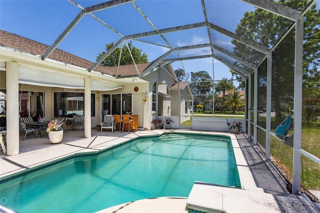 view of swimming pool with a patio area and a lanai