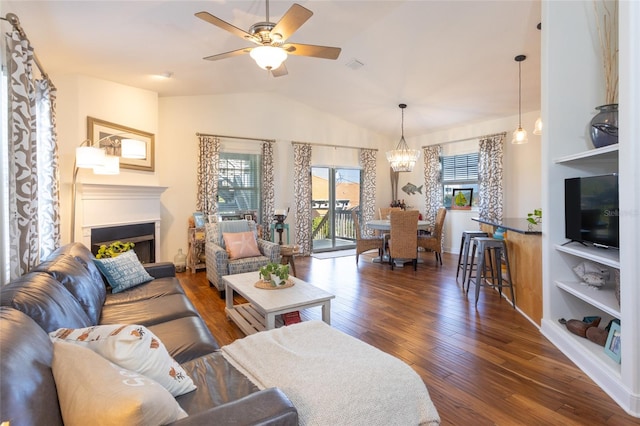 living room with built in features, vaulted ceiling, ceiling fan with notable chandelier, and dark hardwood / wood-style floors