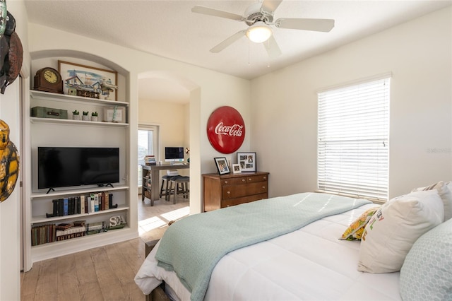 bedroom with hardwood / wood-style floors, multiple windows, and ceiling fan