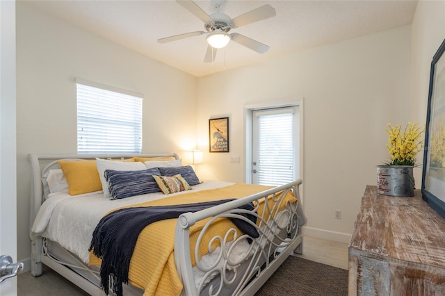 bedroom with multiple windows, ceiling fan, and dark colored carpet