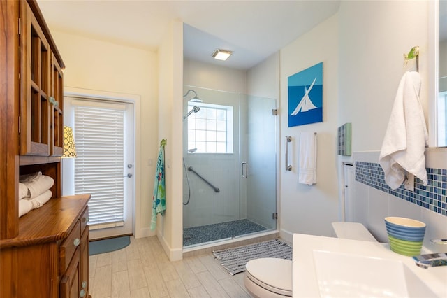 bathroom with vanity, toilet, and a shower with door