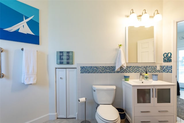 bathroom featuring tile walls, toilet, tile flooring, and vanity