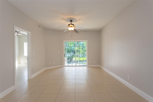 tiled empty room featuring ceiling fan and a textured ceiling