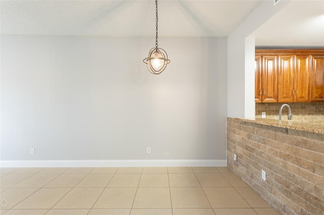 unfurnished dining area featuring light tile patterned floors and sink