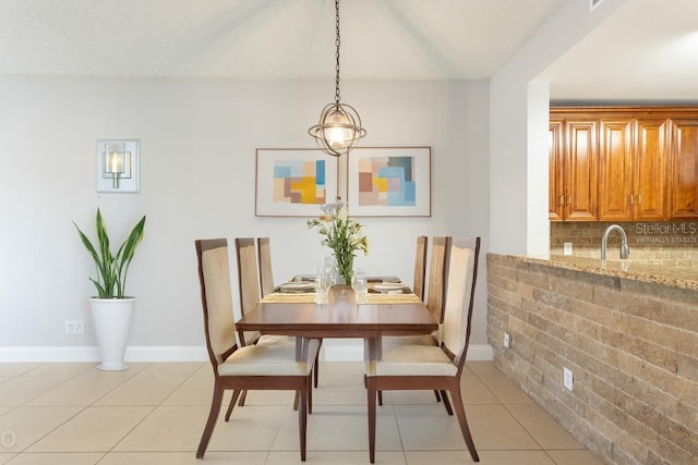 dining room featuring sink, light tile patterned floors, and a textured ceiling