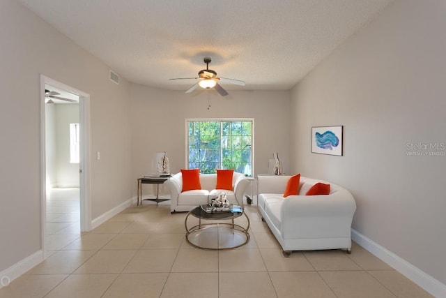 sitting room with ceiling fan, a textured ceiling, and light tile patterned floors