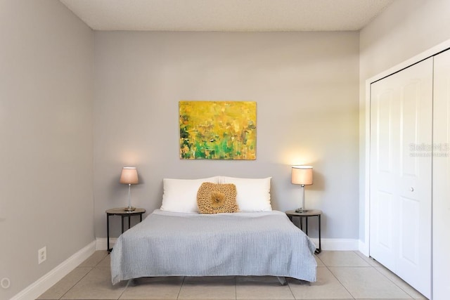 bedroom with a closet and light tile patterned flooring