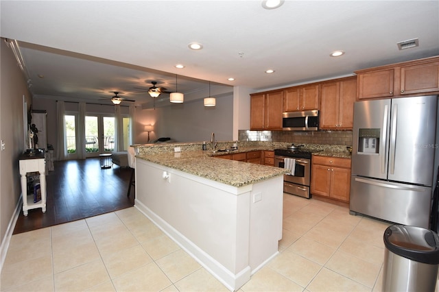 kitchen with light stone counters, ceiling fan, light tile flooring, stainless steel appliances, and kitchen peninsula