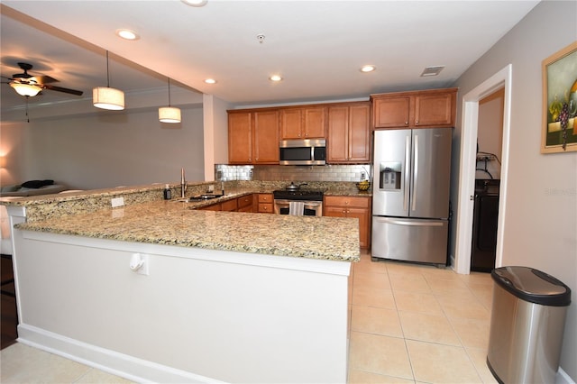 kitchen featuring light stone countertops, stainless steel appliances, kitchen peninsula, and light tile flooring