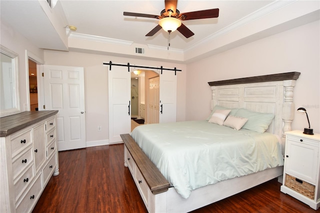 bedroom featuring ceiling fan, a tray ceiling, a barn door, and dark hardwood / wood-style floors