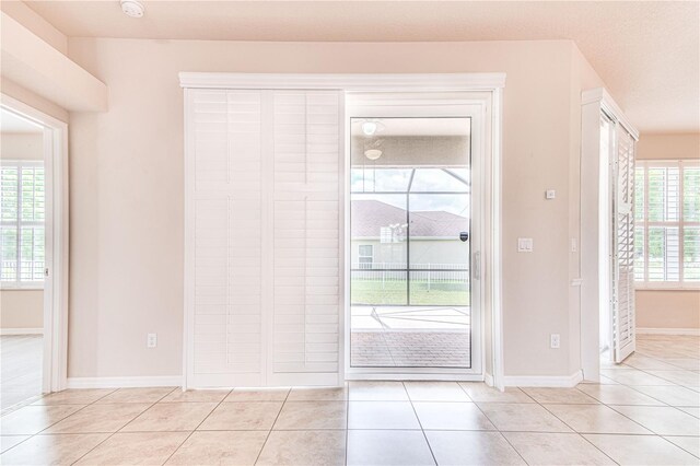 entryway featuring a healthy amount of sunlight, light tile patterned flooring, and a textured ceiling