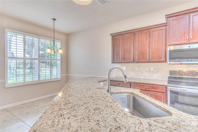 kitchen featuring stove, an inviting chandelier, sink, decorative backsplash, and a textured ceiling