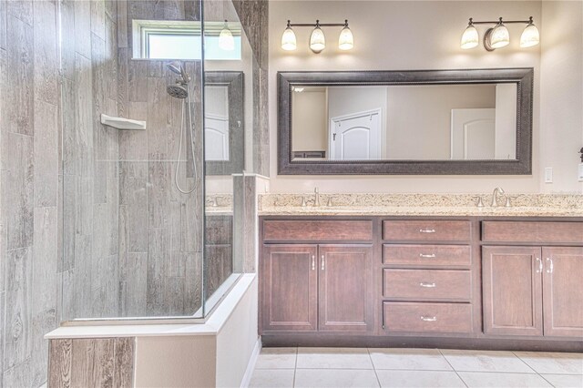 bathroom featuring tile patterned flooring, vanity, and tiled shower