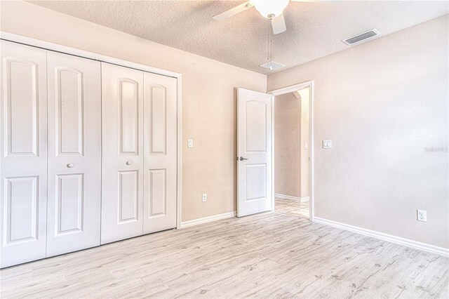 unfurnished bedroom featuring ceiling fan, a closet, and light hardwood / wood-style floors