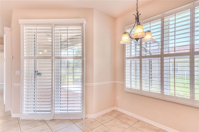 unfurnished dining area featuring light tile patterned flooring and a chandelier