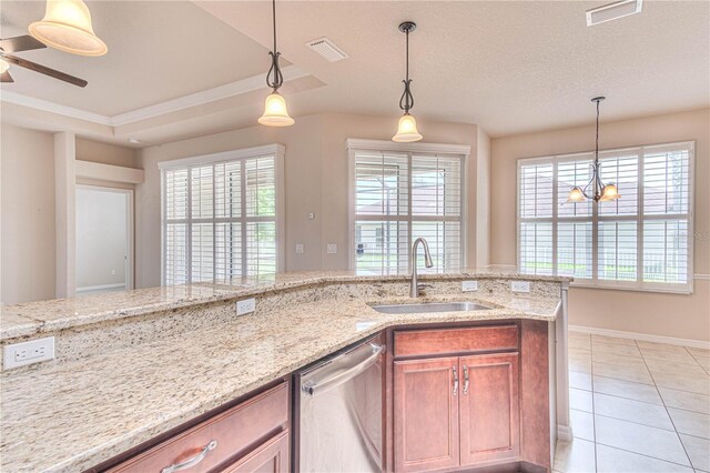 kitchen with light stone counters, sink, light tile patterned floors, dishwasher, and hanging light fixtures