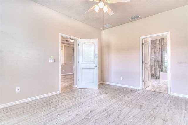 unfurnished bedroom featuring a textured ceiling, light wood-type flooring, ensuite bathroom, and ceiling fan