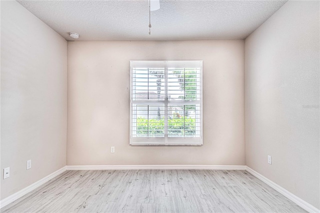 spare room with a textured ceiling, light hardwood / wood-style floors, and ceiling fan