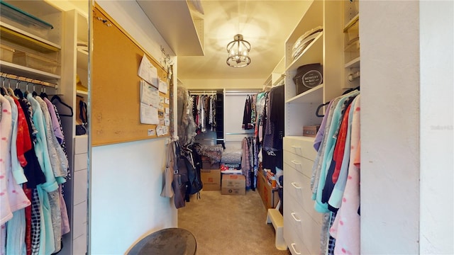 spacious closet with a notable chandelier and carpet floors