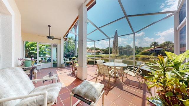 sunroom / solarium with a water view and ceiling fan