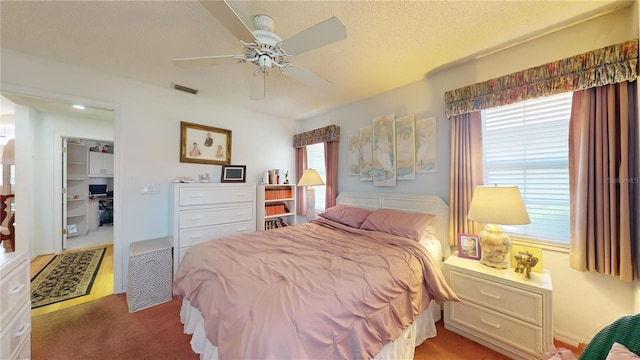 bedroom featuring a textured ceiling, carpet floors, and ceiling fan