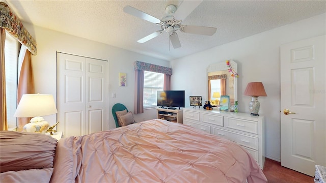 bedroom featuring ceiling fan, a closet, a textured ceiling, and carpet flooring