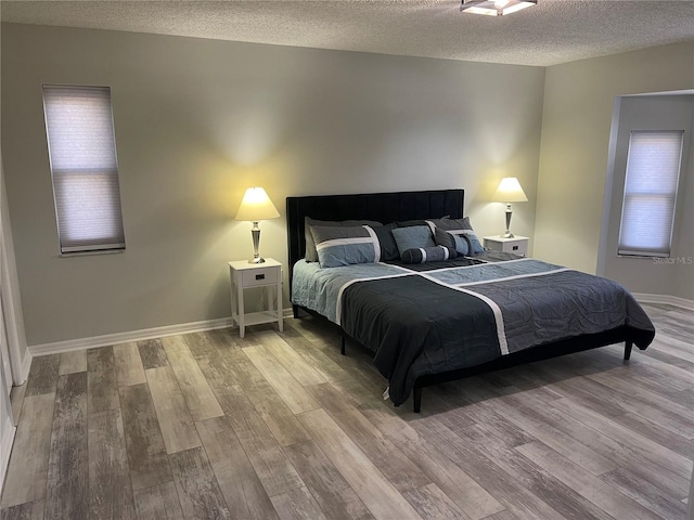 bedroom with a textured ceiling and hardwood / wood-style floors