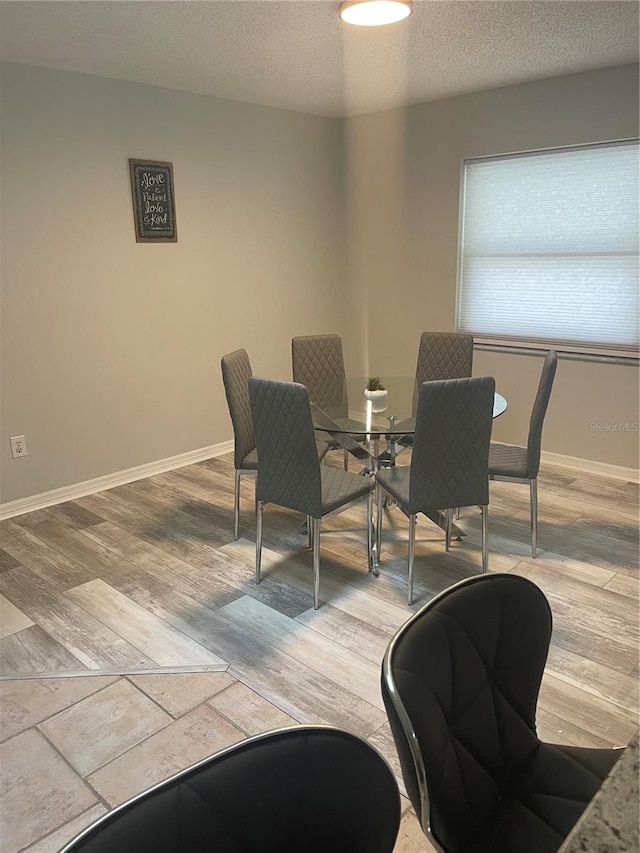 dining area with wood-type flooring and a textured ceiling