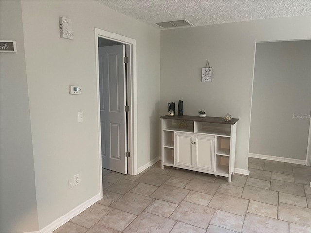 tiled spare room featuring a textured ceiling